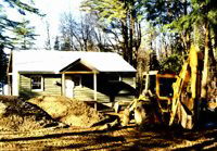 Cabin with snow on the roof and piles of dirt EVERWHERE